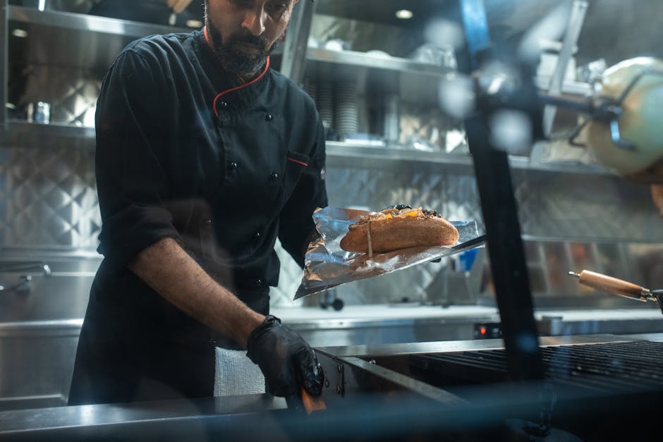 A skilled chef grills a delicious sandwich inside a sleek food truck kitchen