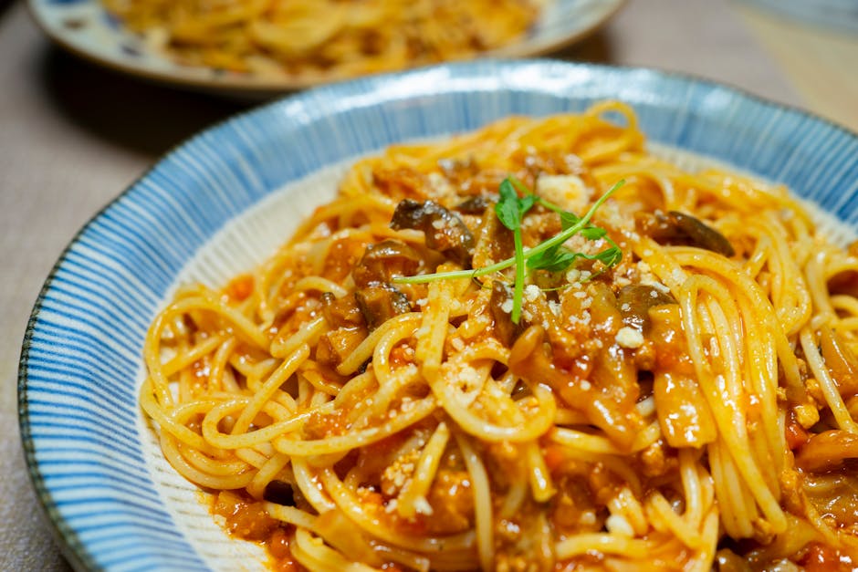 Close-up of a delicious spaghetti dish in tomato sauce with mushrooms and herbs