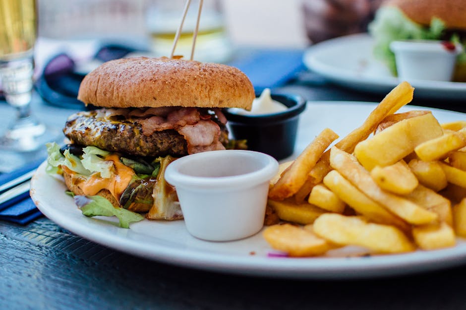 Close-up of a juicy burger and crispy fries served with sauces